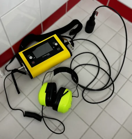 Akustische Leckageortung im Bad mit Trotec LD6000, Bodenmikrofon und Gehörschutz auf Fliesenboden